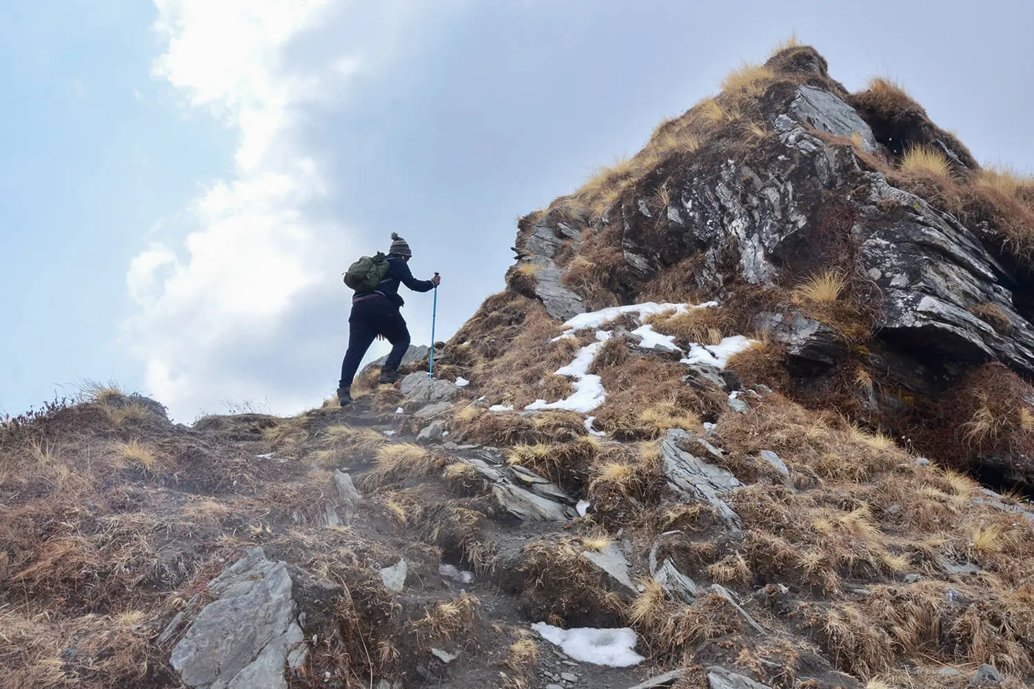A trekker navigates a steep ascent on Brahmatal Trek