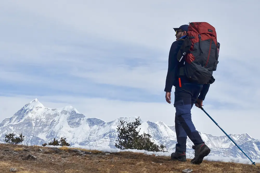 A trekker admiring the mighty Mt. Trishul on Brahmatal Trek in Uttarakhand.
