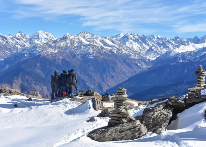 A group of trekkers mesmerized by spell binding mountainscape from Kedarkantha summit.