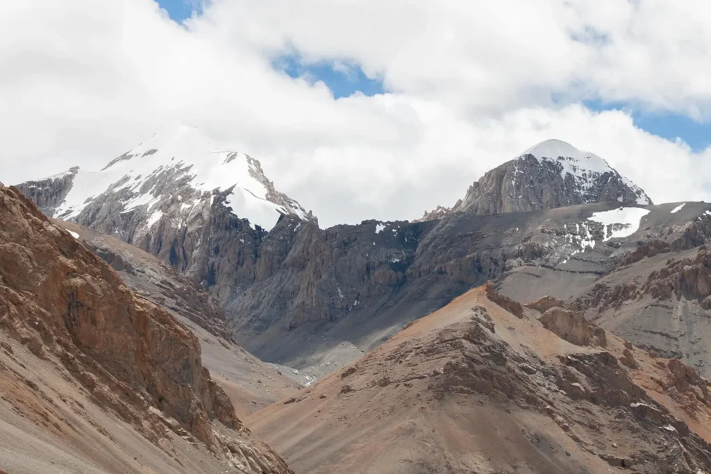 Snow-covered peaks and barren mountains on Parang La Trek in July