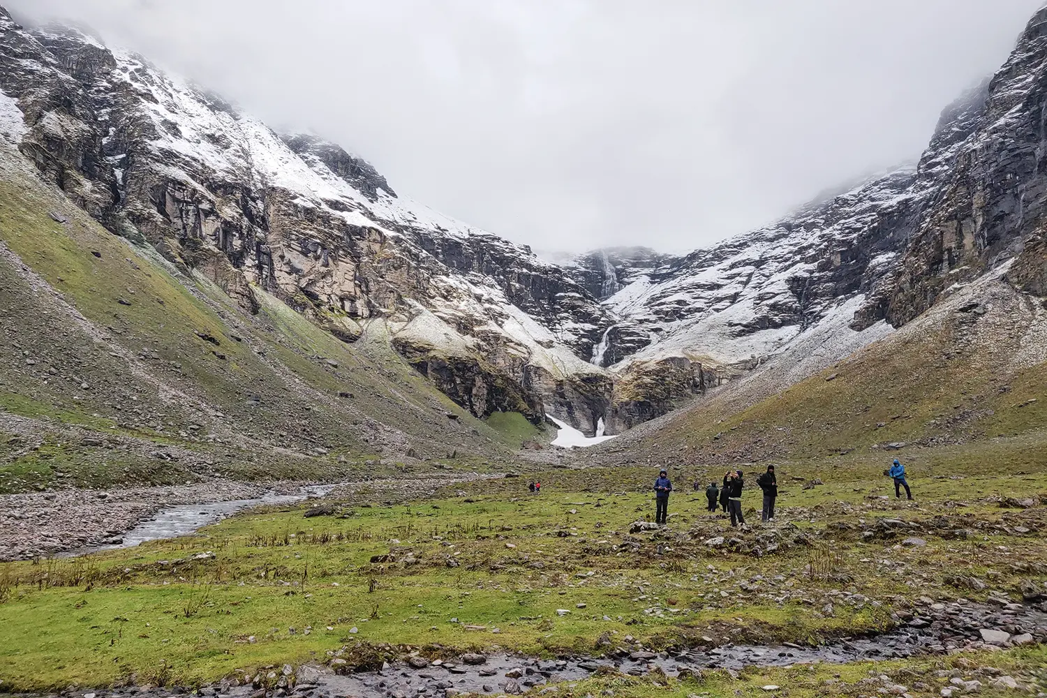 A group of trekkers amazed by the famous three stage waterfall on Rupin Pass trek.