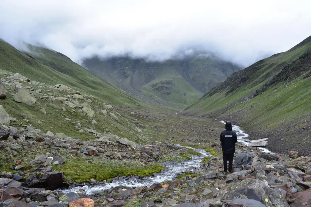 A trekker immerses in a breathtaking landscapes on Pin Bhaba Pass Trek.